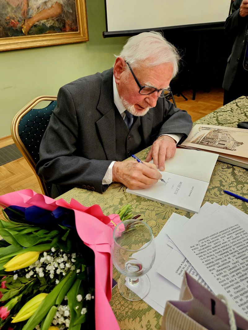 Jerzy Żurawski podpisujący książkę