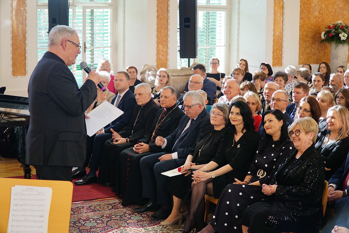 Sala Balowa, goście wydarzenia siedzą na krzesłach, przemawia Z. Magoń