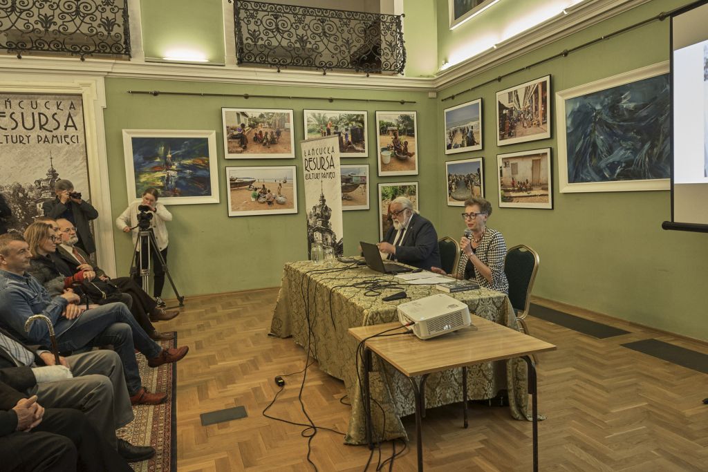  Widok na autorkę Zuzannę Guzel-Szczepiórkowską oraz moderatora spotkania - Wita Karola Wojtowicza, siedzących przy stoliku czynnych uczestników spotkania.