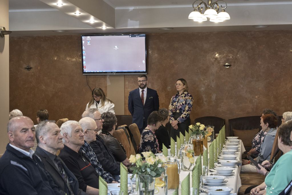 Sala bankietowa, goście siedzą przy stole, na środku sali przemawiają p. o. Dyrektora Muzeum - Zamek w Łańcucie Krzysztof Żaba, Główna Księgowa Marzena Machniak, Przewodnicząca Związków Zawodowych "Solidarność" Muzeum - Zamek w Łańcucie Bożena Lauzer.