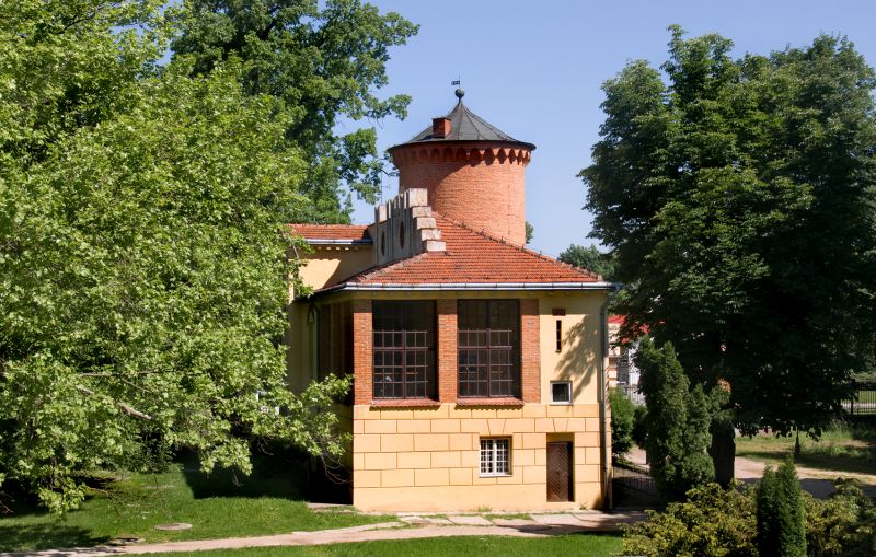 Zameczek - ujęcie od strony Storczykarni, dookoła zielone drzewa, słoneczna pogoda 